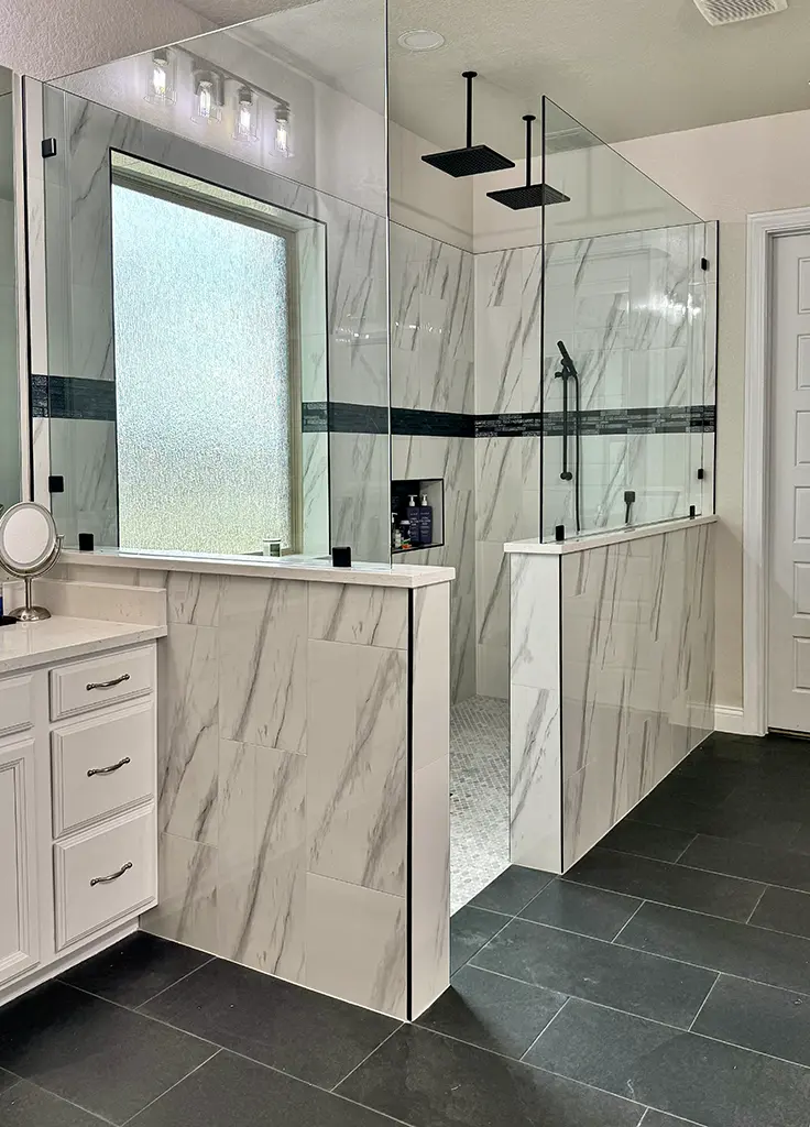 Master bathroom after remodel with marble tile walk-in shower, dual rainheads, and slate floor in San Antonio