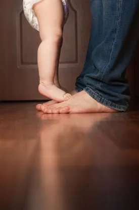 Family walking barefoot on beautiful hardwood flooring in San Antonio home