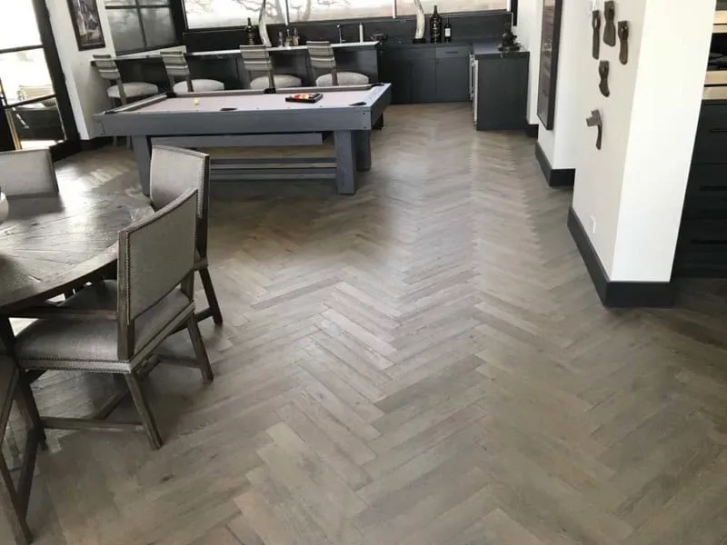 Gray herringbone hardwood flooring pattern in San Antonio game room